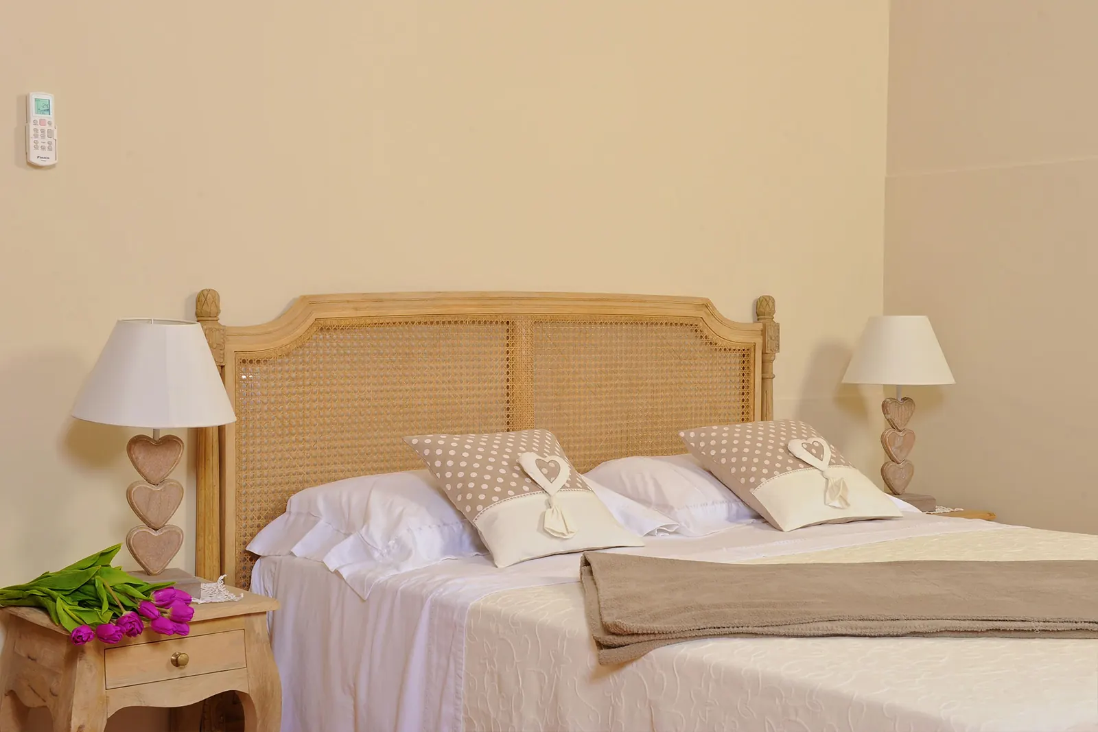 Camera con letto in rattan e comodini a forma di cuore
